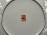 une assiette blanche ornée d'un motif rouge