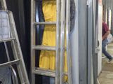 une échelle appuyée contre un mur, sur laquelle est posé un manteau jaune