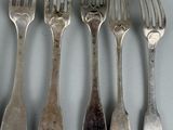 five forks and five spoons on the table
