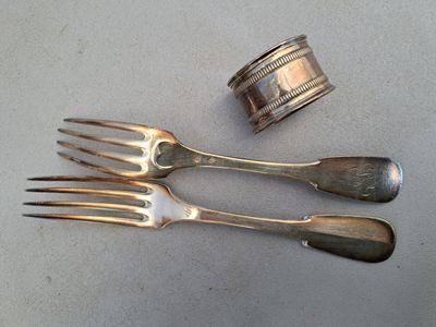 deux fourchettes et une serviette sur la table