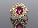 gros plan d'une bague en or avec un rubis et un diamant au centre