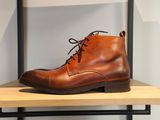 des bottes en cuir posées sur une étagère dans un magasin de chaussures