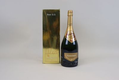 a close up of a bottle of champagne next to a gold box