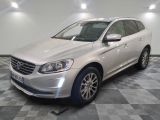 the white volvo suv is parked in a clean room
