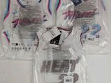 trois sacs de t-shirts sont emballés dans du plastique sur une table