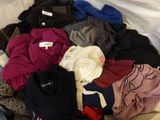 un tas de vêtements sur un lit recouvert d'un drap blanc
