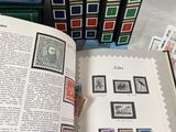 a book with stamps on it sitting next to a stack of books