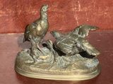 une statue en bronze représentant deux oiseaux perchés sur un rocher