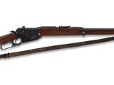 un fusil avec un canon en bois et une bretelle en bois sur fond blanc
