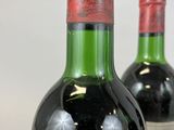 two bottles of wine sitting next to each other on a table