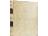 an old book sitting on top of a white surface