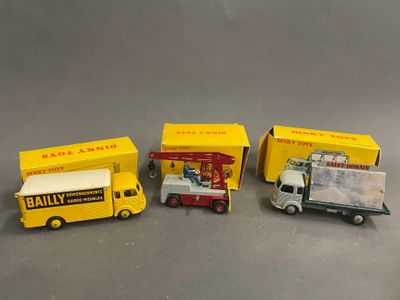 Quatre camions miniatures sont alignés en rang sur une table