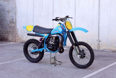 a blue dirt bike parked in a parking lot