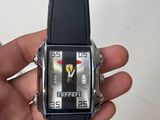 Quelqu'un tient dans sa main une montre arborant le logo Ferrari.