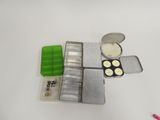 a small tin with some buttons in it on a table