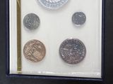 four different coins in a box on a table