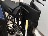 un fauteuil roulant qui se trouve dans une pièce, à côté d'une poubelle