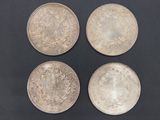 three silver coins on a black surface