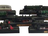 cinq modèles réduits de trains exposés sur un fond blanc