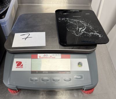une balance numérique sur laquelle est posée une tablette