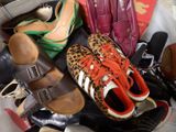a pile of shoes and purses on the floor