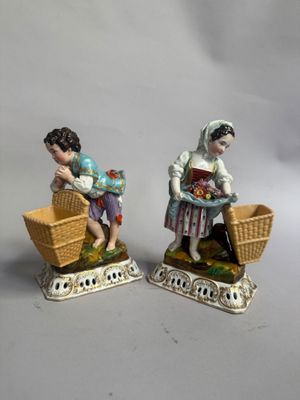 deux figurines représentant une femme et un enfant assis dans un panier