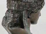 bronze statue of a woman with a hat on her head