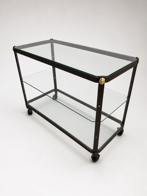 an image of a glass and brass coffee table on wheels