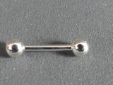 a close up of a silver nose piercing on a gray surface