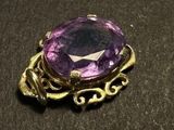 an image of a close up of a purple stone in a broochle