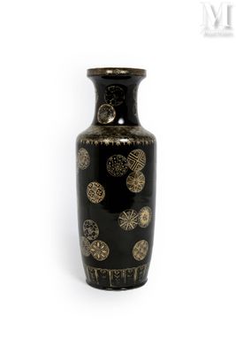 un vase noir orné de motifs dorés sur fond blanc