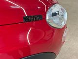 a close up of a red car with a sticker on it