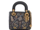 a black handbag with a gold chain and a flower design