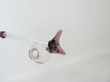 a glass vase with a purple flower inside of it