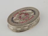 an ornate silver box with a pink and blue design on it