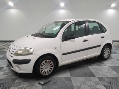 la photo d'une petite voiture blanche garée sur un sol en damier