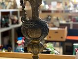 a bronze vase sitting on a table in a store