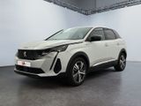 Une voiture blanche est garée dans une grande pièce.