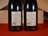 two bottles of wine sitting next to each other on a table