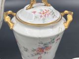 a white tea pot with a gold handle and two cups