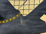 a close up of a t - shirt with a yellow chain on it