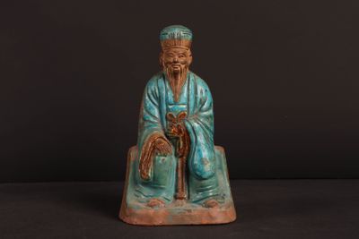une image représentant la statue d'un homme assis sur un rocher