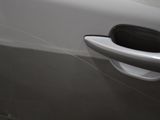 a close up of a car door handle with a spider web on it