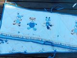 un ensemble de literie pour bébé bleu et blanc orné d'oursons