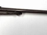 un fusil accroché au mur d'une pièce aux murs blancs
