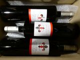 trois bouteilles de vin rangées dans une boîte en carton