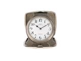une petite horloge en argent posée sur une table