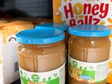 two jars of peanut butter sit on a shelf in a store