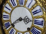 a gold clock with blue and white designs on it
