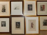 many framed pictures hanging on the wall of a room